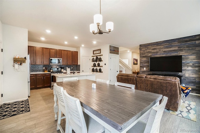 dining space with a notable chandelier and light wood-type flooring