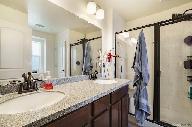 bathroom with a shower with shower door and vanity