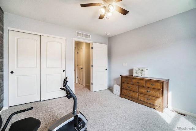 workout area featuring ceiling fan and light colored carpet