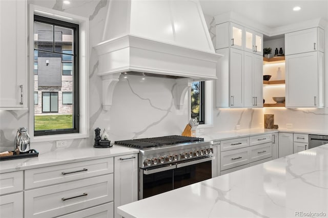 kitchen featuring tasteful backsplash, open shelves, custom range hood, stainless steel appliances, and white cabinetry