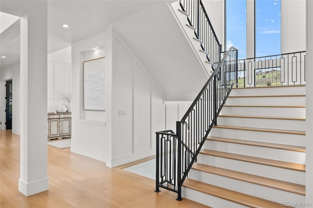 staircase with baseboards, recessed lighting, and wood finished floors