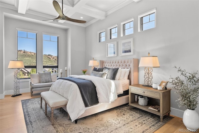 bedroom featuring crown molding, wood finished floors, beam ceiling, baseboards, and coffered ceiling
