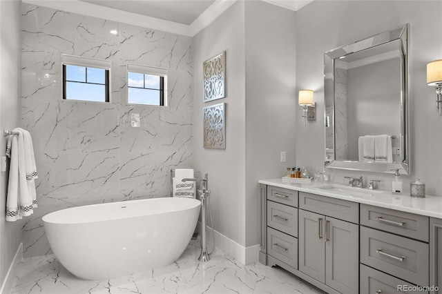 bathroom with stone wall, a soaking tub, marble finish floor, and vanity