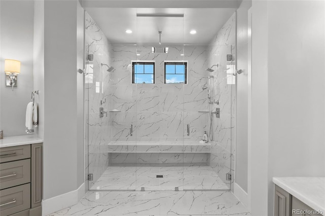bathroom featuring vanity, marble finish floor, baseboards, a tub with marble appearance, and a marble finish shower