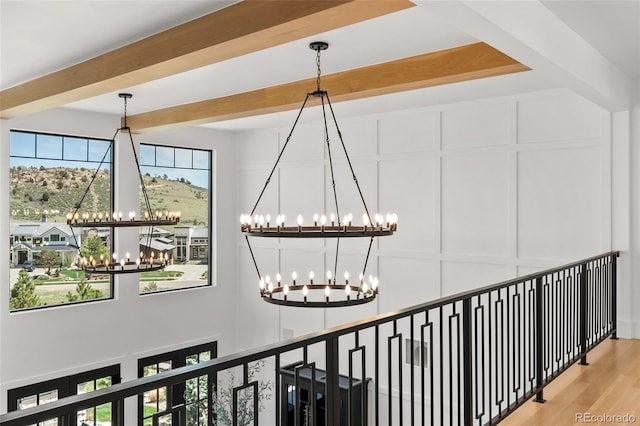 details featuring a decorative wall, wood finished floors, a notable chandelier, and beamed ceiling