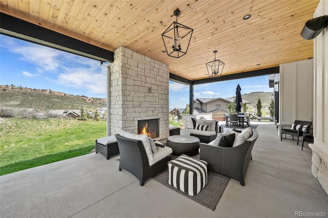 view of patio / terrace with an outdoor living space with a fireplace and a mountain view
