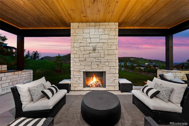 patio terrace at dusk with an outdoor living space with a fireplace