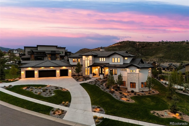 view of front of house featuring an attached garage, curved driveway, stone siding, and a front lawn