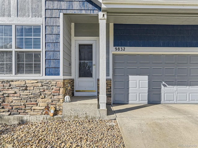 9832 Kenton Cir, Commerce City, CO 80022 - doorway to property with stone siding, driveway, and a garage