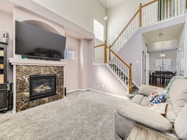 9832 Kenton Cir, Commerce City, CO 80022 - carpeted living area featuring stairway, a high ceiling, healthy amount of natural light, a premium fireplace, and baseboards