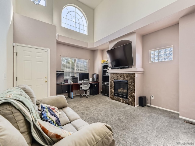 9832 Kenton Cir, Commerce City, CO 80022 - living room featuring a towering ceiling, carpet flooring, a premium fireplace, an office area, and baseboards
