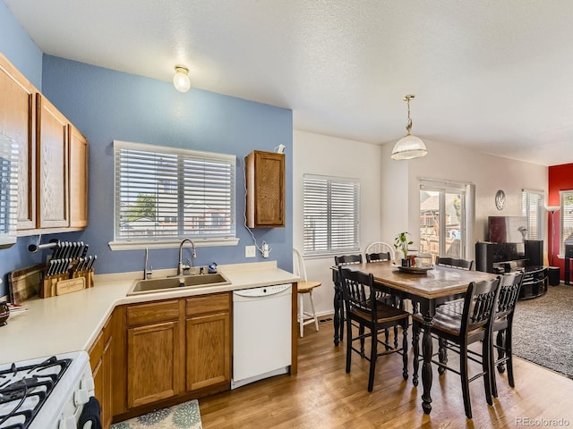9832 Kenton Cir, Commerce City, CO 80022 - kitchen with white appliances, a sink, light wood finished floors, light countertops, and brown cabinetry
