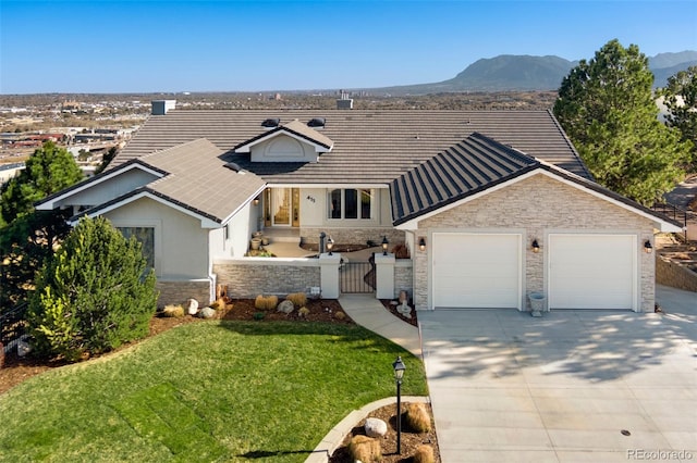 view of front of home with a fenced front yard, stone siding, a gate, an attached garage, and driveway