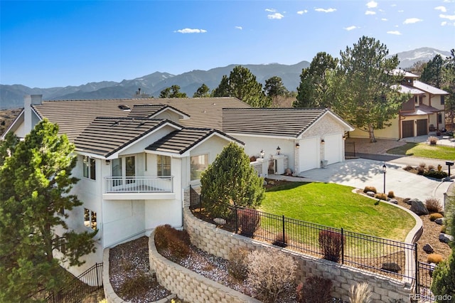 view of front facade with a mountain view, driveway, a garage, a tiled roof, and fence