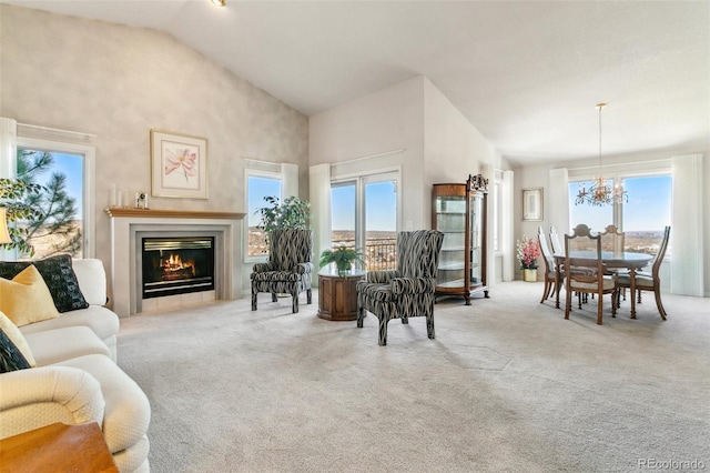 living area featuring carpet floors, high vaulted ceiling, plenty of natural light, and a notable chandelier