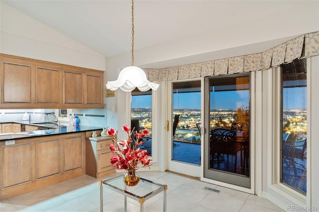 dining space featuring visible vents, vaulted ceiling, and light tile patterned flooring
