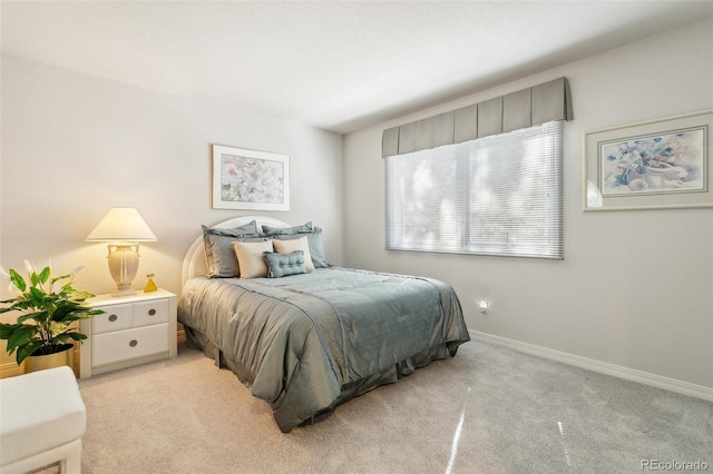 bedroom with baseboards and light colored carpet