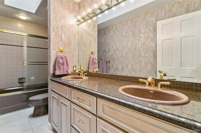 full bathroom with tile patterned flooring, a sink, wallpapered walls, and toilet