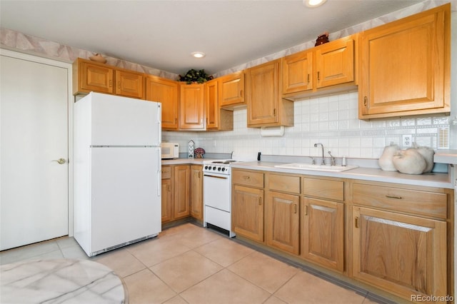 kitchen featuring white appliances, light tile patterned flooring, light countertops, a sink, and backsplash