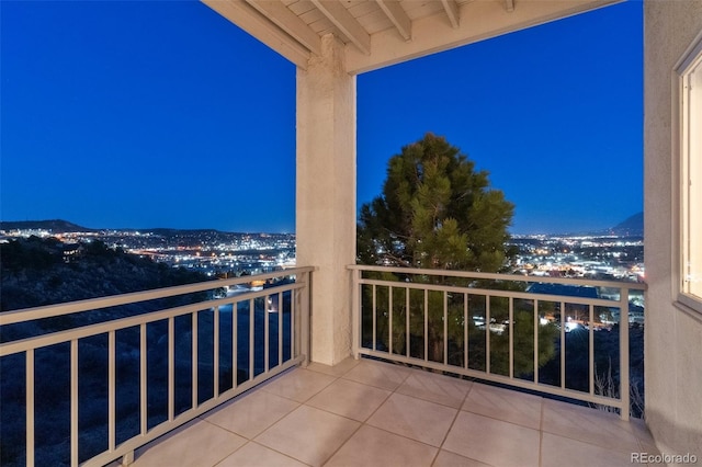 balcony at night featuring a view of city lights