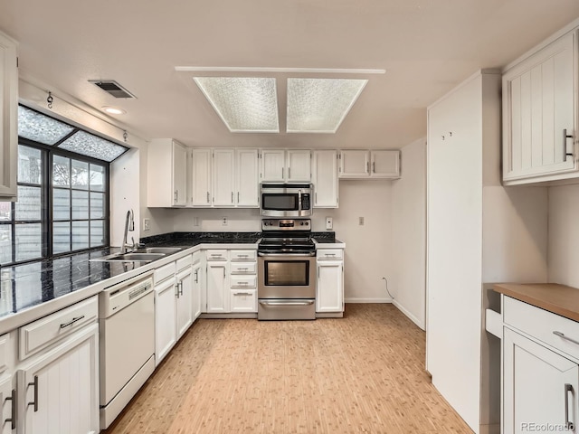 kitchen featuring sink, white cabinets, stainless steel appliances, and light wood-type flooring