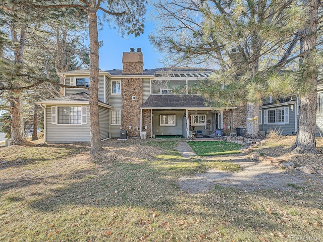 rear view of house featuring a patio, a yard, and central air condition unit