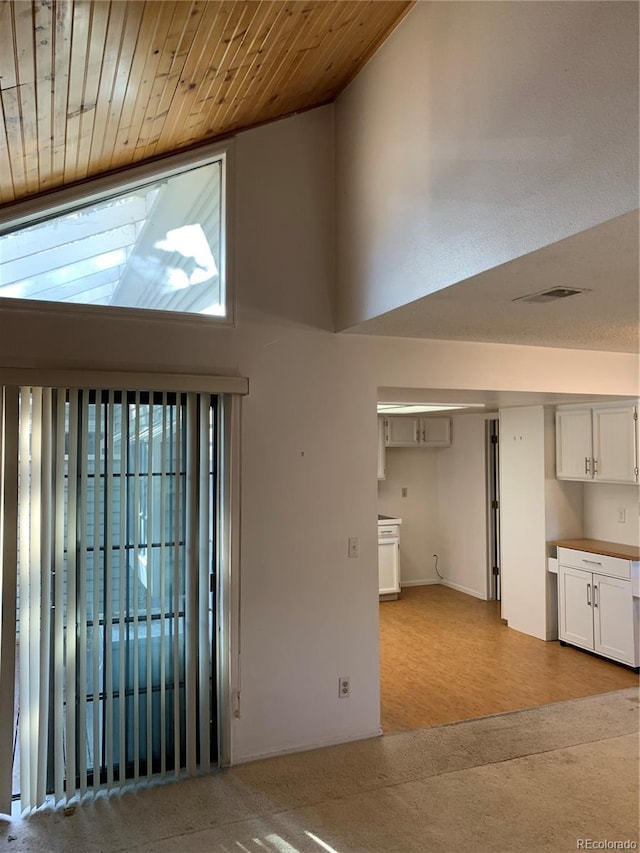 entryway with wood ceiling and high vaulted ceiling