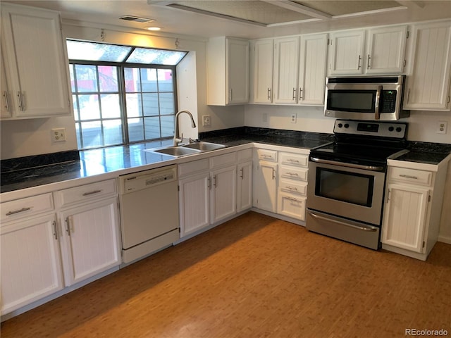 kitchen featuring white cabinetry, sink, light hardwood / wood-style flooring, and stainless steel appliances