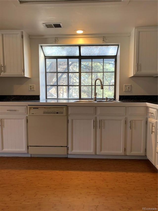 kitchen featuring sink, white cabinets, and dishwasher