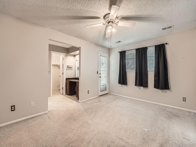 carpeted spare room featuring a textured ceiling and ceiling fan