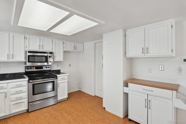 12622 E Warren Dr Unit E, Aurora, CO 80014 - kitchen featuring light wood-type flooring, white cabinets, and appliances with stainless steel finishes