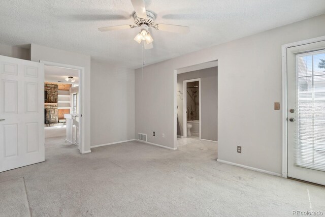12622 E Warren Dr Unit E, Aurora, CO 80014 - unfurnished room featuring a ceiling fan, a fireplace, carpet floors, visible vents, and baseboards