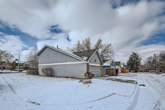 snow covered property featuring a garage