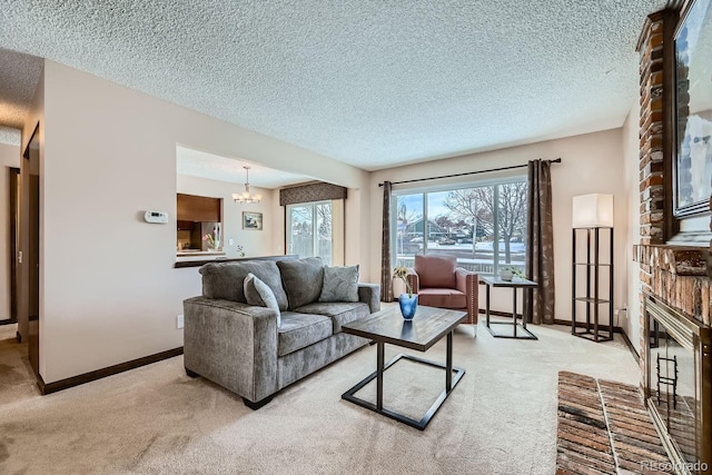 living room featuring an inviting chandelier, light colored carpet, a textured ceiling, and a fireplace