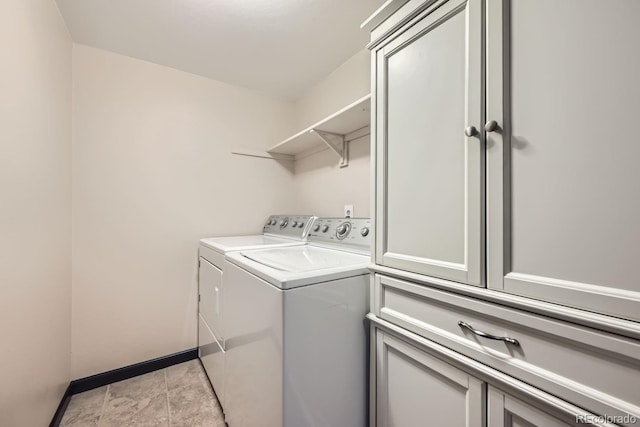 clothes washing area featuring cabinets and independent washer and dryer