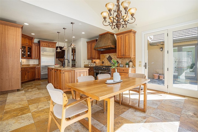 dining space with recessed lighting, a notable chandelier, and stone tile floors