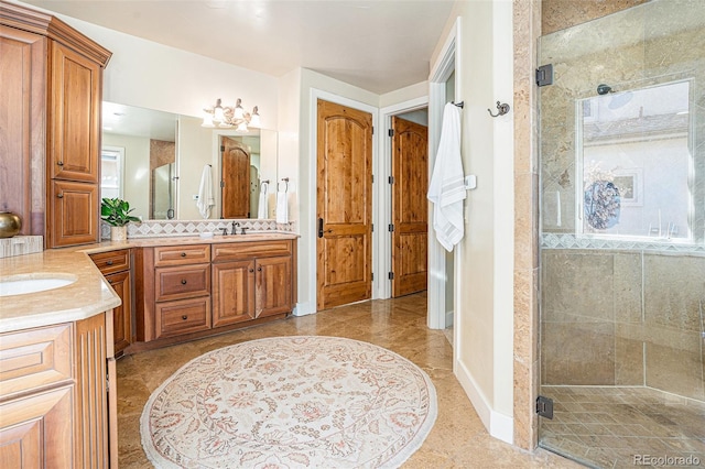 full bathroom with a stall shower, vanity, and baseboards