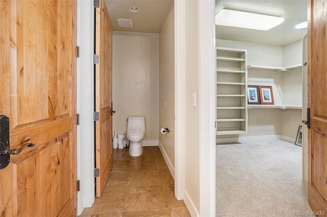 bathroom with toilet and baseboards