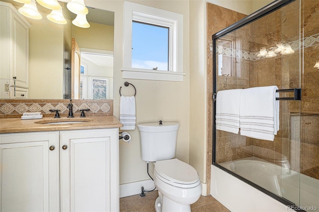 bathroom with toilet, vanity, combined bath / shower with glass door, decorative backsplash, and tile patterned floors