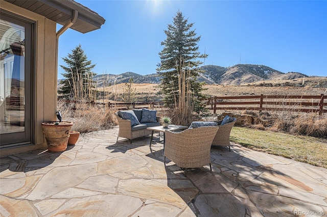 view of patio / terrace with an outdoor hangout area, fence, and a mountain view