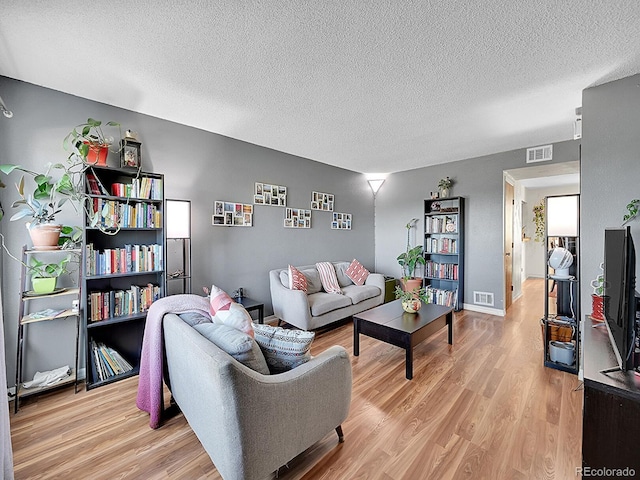 living room with light hardwood / wood-style flooring and a textured ceiling