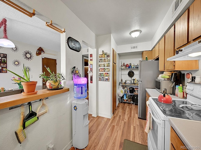 kitchen with white electric range oven, light wood-type flooring, a textured ceiling, and range hood