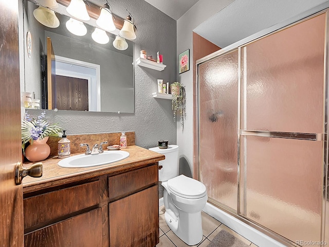 bathroom with vanity, tile patterned flooring, an enclosed shower, and toilet