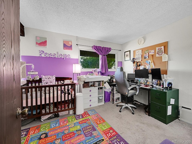 carpeted bedroom with a textured ceiling and a nursery area