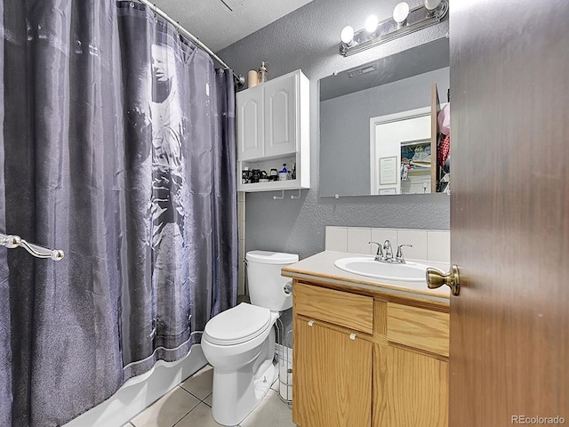 bathroom with tile patterned flooring, a textured ceiling, vanity, and toilet