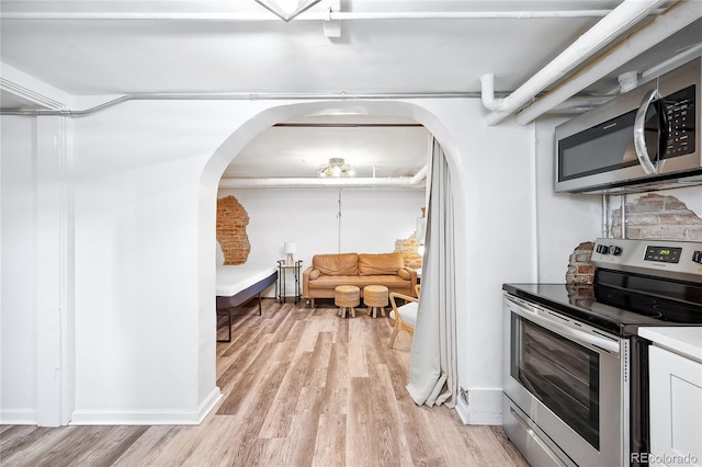 kitchen featuring tasteful backsplash, appliances with stainless steel finishes, and light wood-type flooring