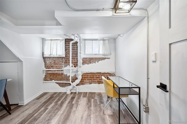 office featuring brick wall and wood-type flooring