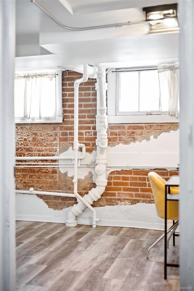 1331 N Ogden St Unit 1, Denver, CO 80218 - kitchen featuring brick wall, white cabinetry, and wood finished floors