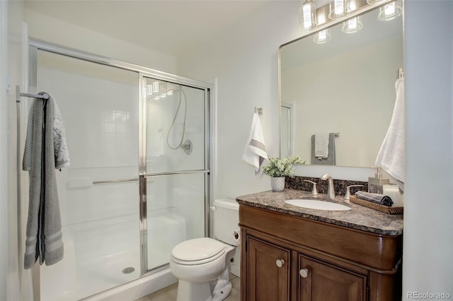 bathroom featuring vanity, toilet, and an enclosed shower