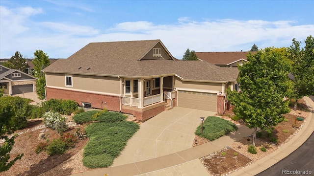 22873 E David Pl, Aurora, CO 80016 - view of front of home featuring brick siding, driveway, a shingled roof, a garage, and a porch